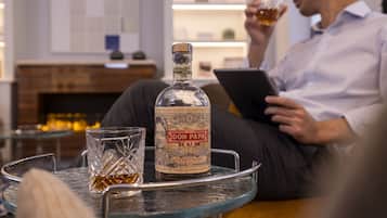 Uma garrafa de rum Don Papa sobre uma mesa de vidro, com um copo ao lado.