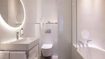 A modern bathroom with a large sink, toilet, and bathtub.