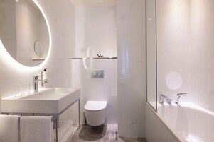 A modern bathroom with a large sink, toilet, and bathtub.