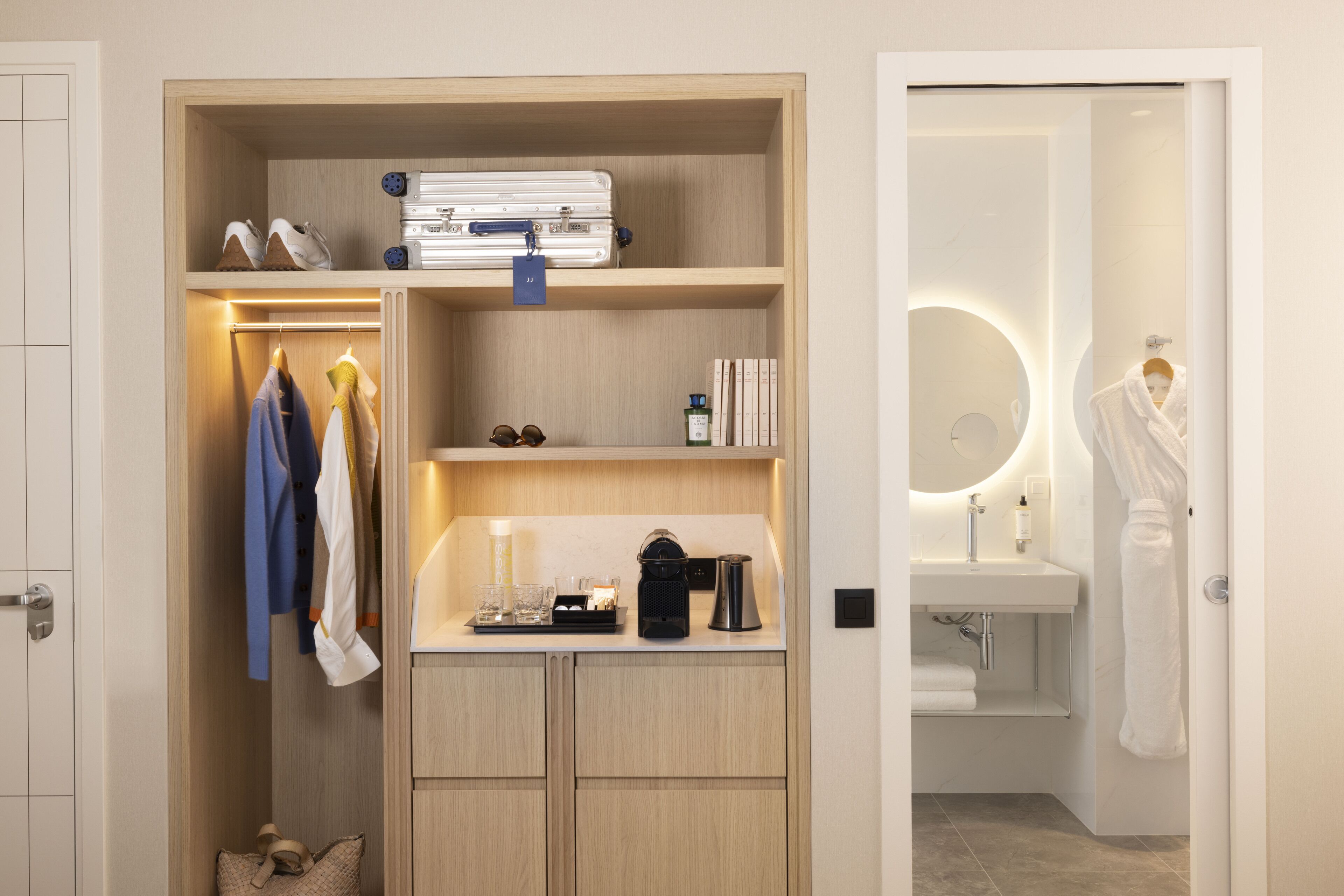 A walk-in closet with shelves, a hanging rack, and a small table with a kettle and cups.