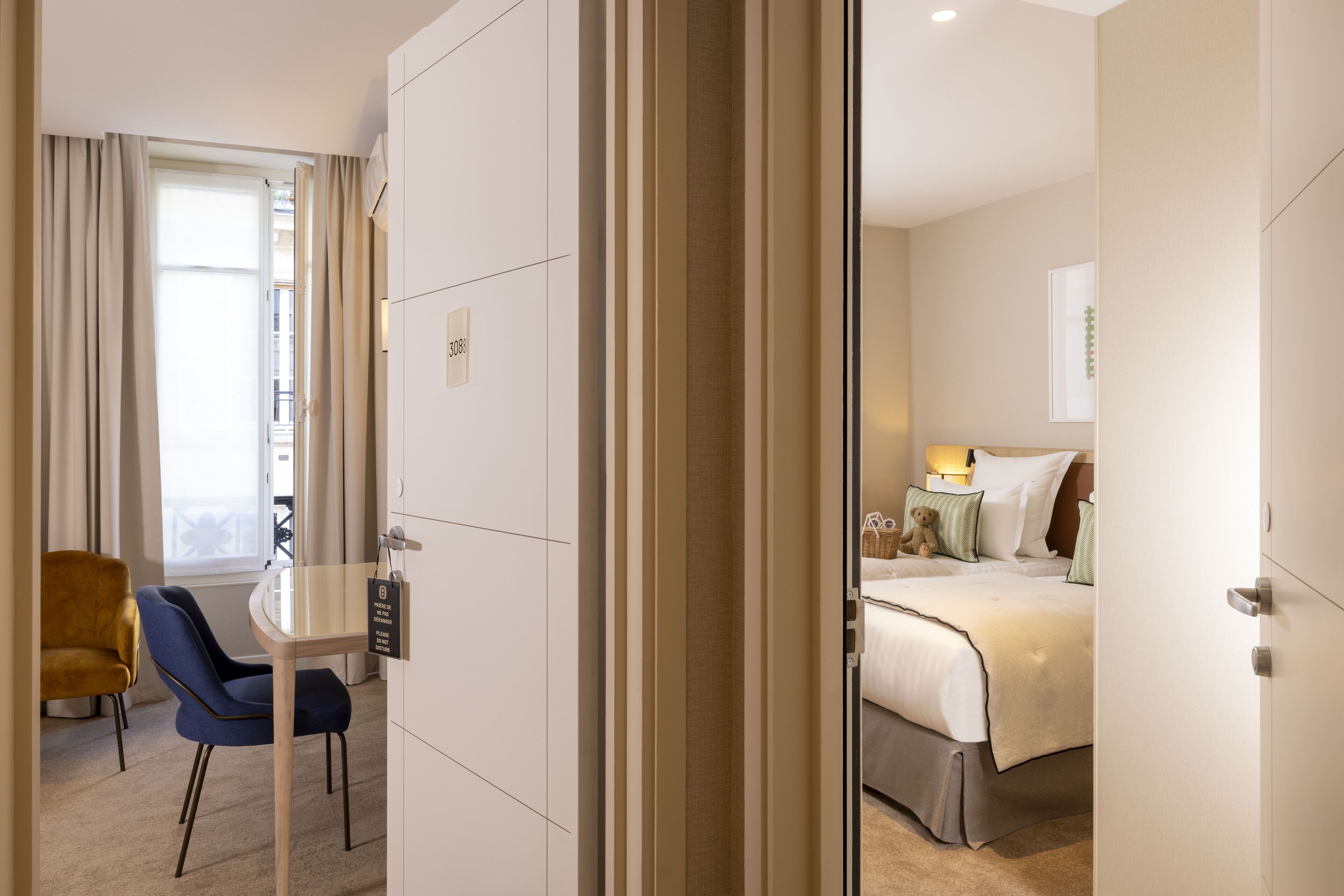 A hotel room with a bed, bedside table, lamp, and a chair.