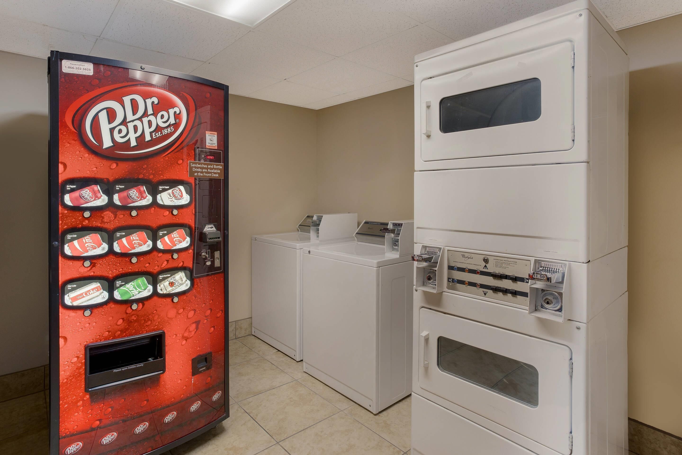 A vending machine with various drinks and a stacked washer and dryer unit.