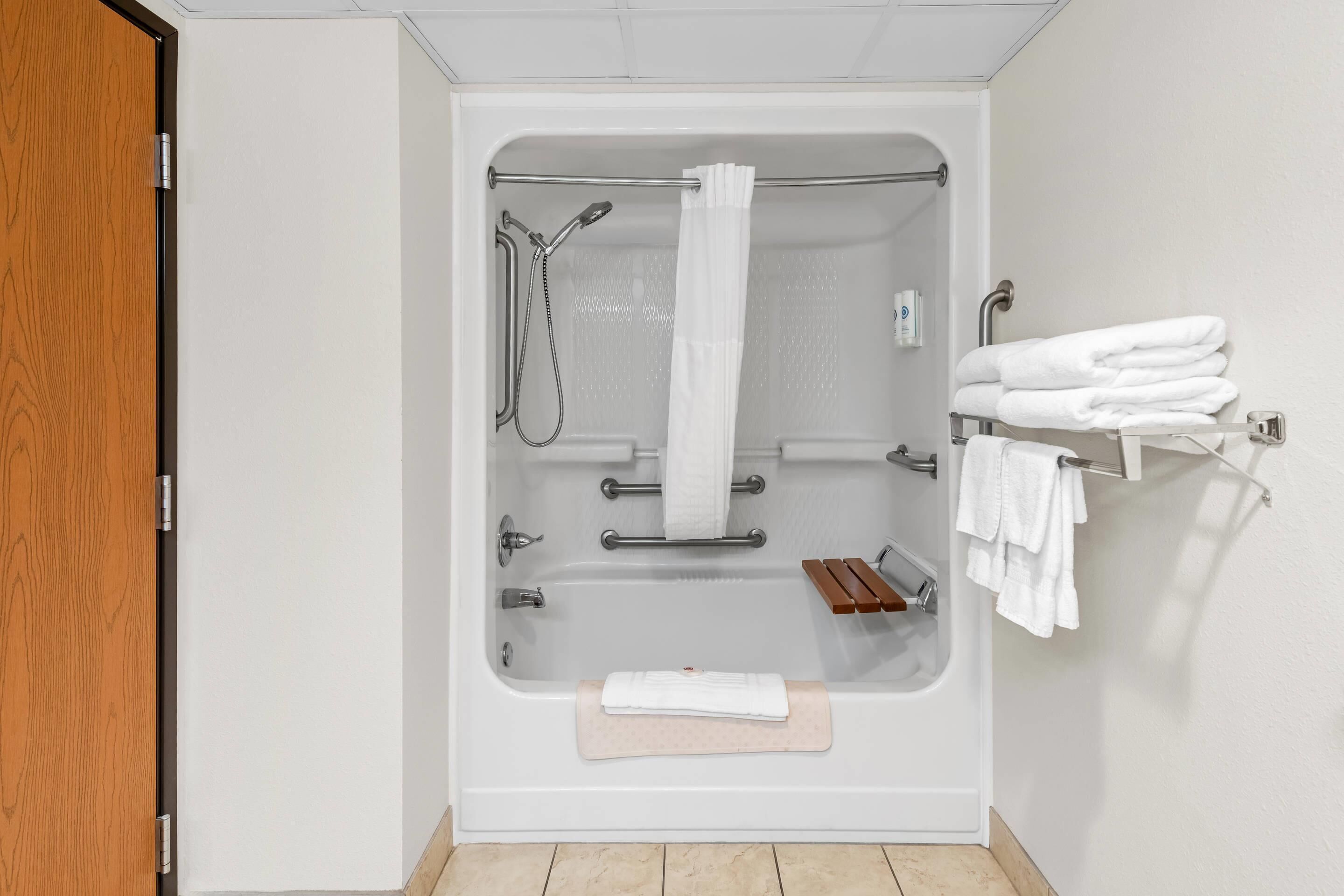 Un baño moderno con bañera, ducha y toallero.