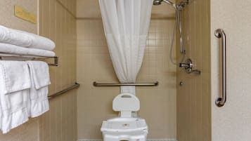 A wheelchair-accessible shower stall with a white shower curtain, a grab bar, and a white toilet.