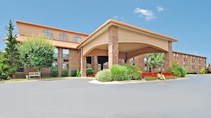 A large hotel with a covered entrance, multiple windows, and landscaped gardens. - Comfort Inn at Thousand Hills (Branson)