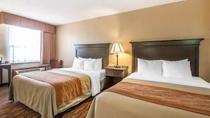 A hotel room with two beds, a nightstand with a lamp, and a window with curtains. - Comfort Inn at Thousand Hills (Branson)