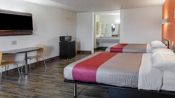 A hotel room with two beds, a TV, a desk, and a chair.