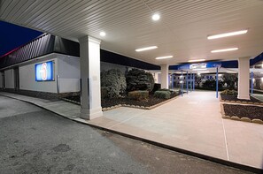 A modern building entrance with a registration lobby sign, a large illuminated number 6 sign, and a well-maintained landscaped area. - Motel 6 Staunton, VA (Staunton)
