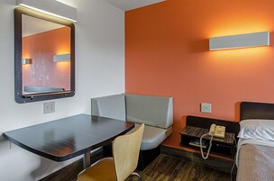 Espacio para trabajar con laptop y tabla de planchar con plancha 