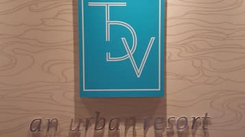 Un logo comprenant les lettres « TV » et les mots « un lieu de détente urbain », le tout sur un fond en bois.