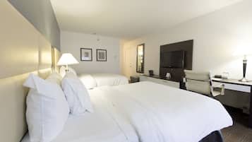 Een hotelkamer met twee bedden, een bureau, een stoel, een televisie en een lamp.