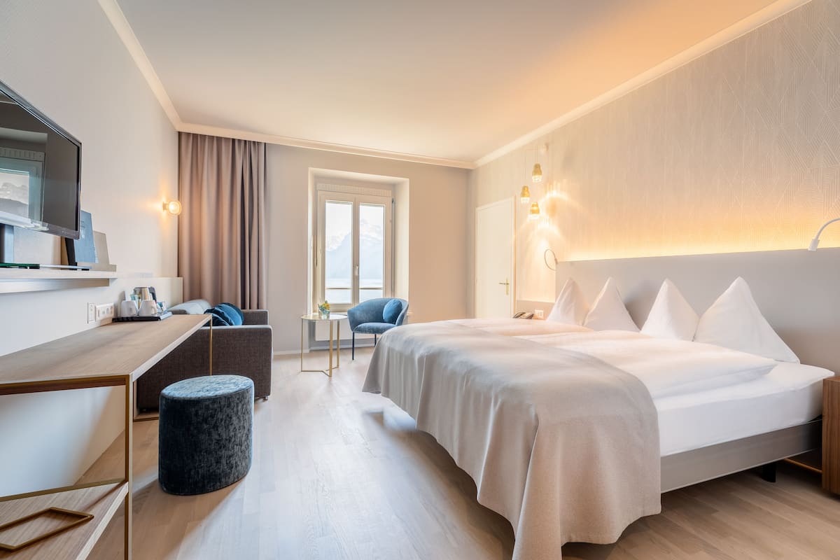 Une chambre d’hôtel moderne équipée d’un lit, d’un bureau, d’une chaise et d’un téléviseur.