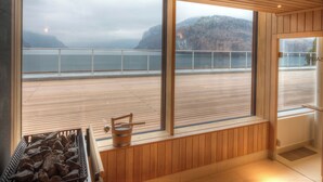 Eine Holterrasse mit Blick auf ein Gewässer und Berge.