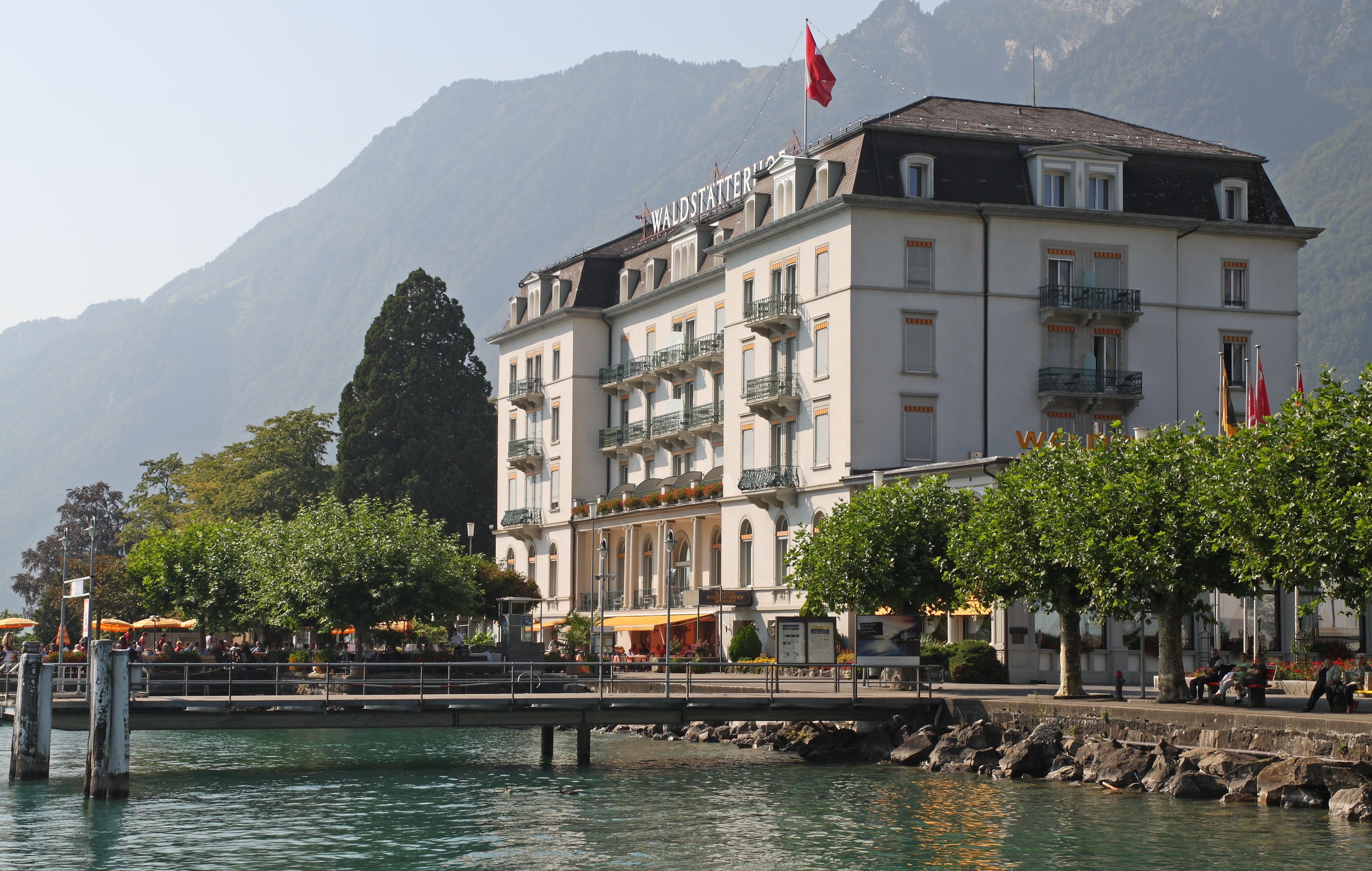 A hotel with a prominent sign, a waterfront view, and a bridge in the foreground.