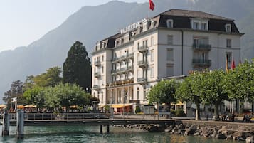 A hotel with a prominent sign, a waterfront view, and a bridge in the foreground.