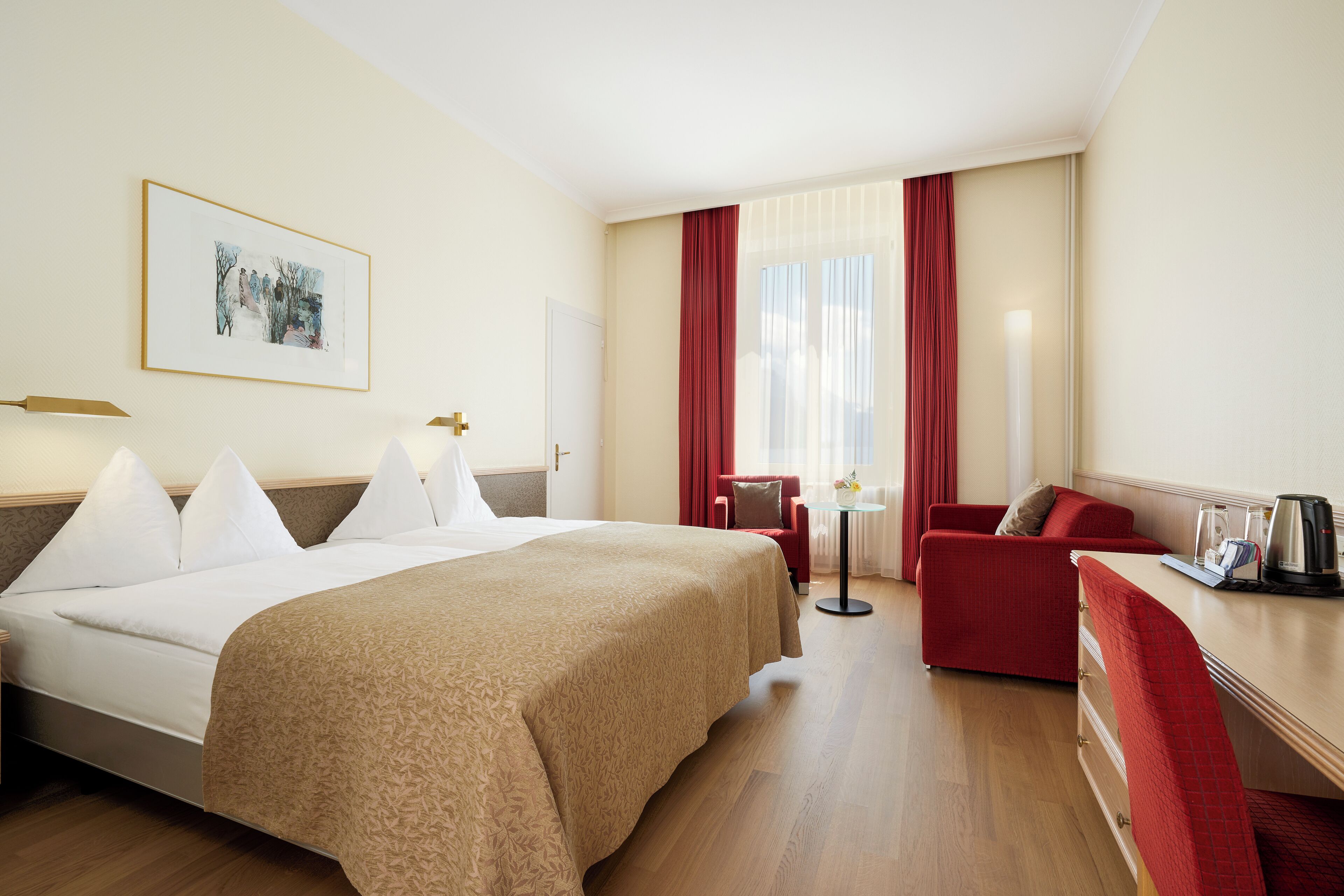 Une chambre d’hôtel avec un grand lit, un bureau, une chaise et une petite table.
