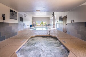 Un área de spa con un jacuzzi, asientos y vistas al exterior.