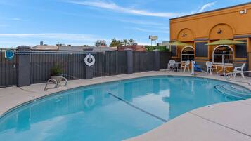 Una piscina al aire libre de temporada, sombrillas