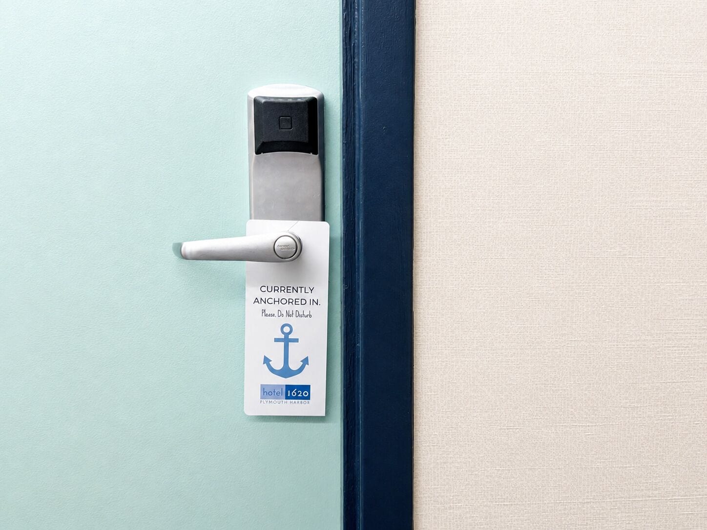 A door with a sign indicating it is currently anchored, a handle, and a small electronic lock.