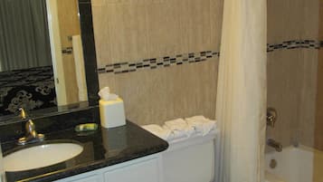 Une salle de bain équipée d’un lavabo, d’un miroir, de toilettes et d’une baignoire.