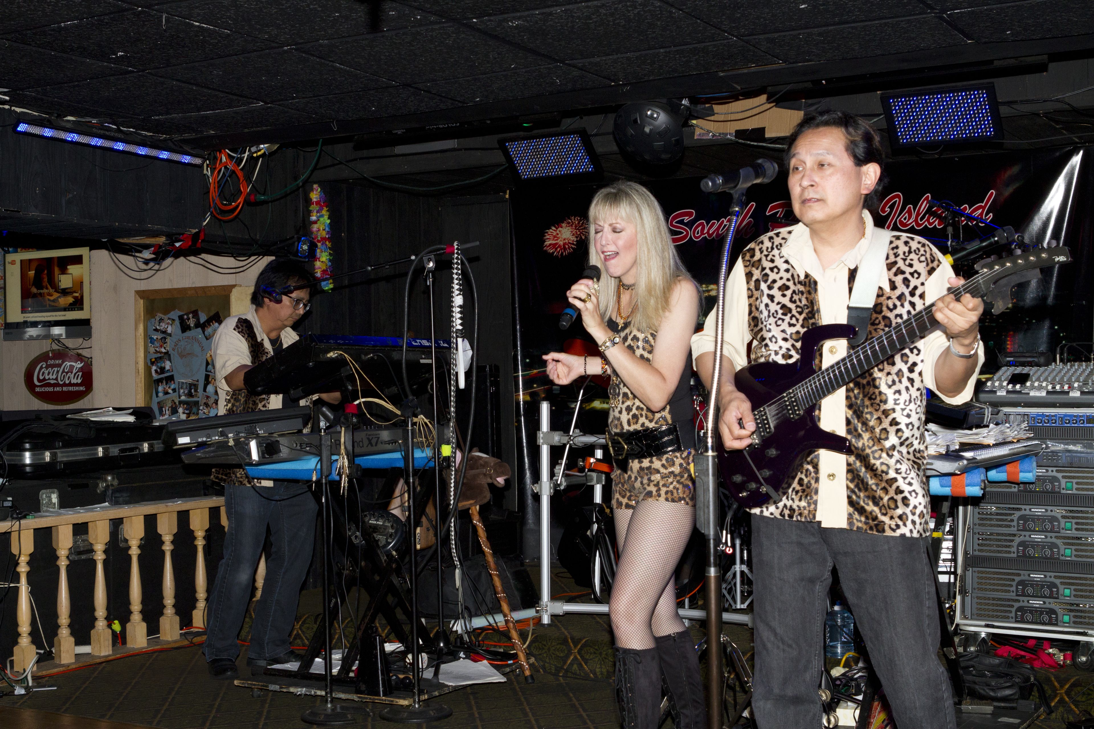 A band performing on stage with musical instruments and equipment.