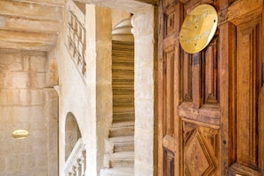 Un escalier en pierre, une porte en bois et une plaque en laiton.