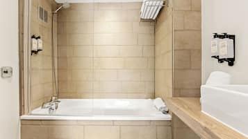 Un baño moderno con bañera, ducha y un perchero para toallas.