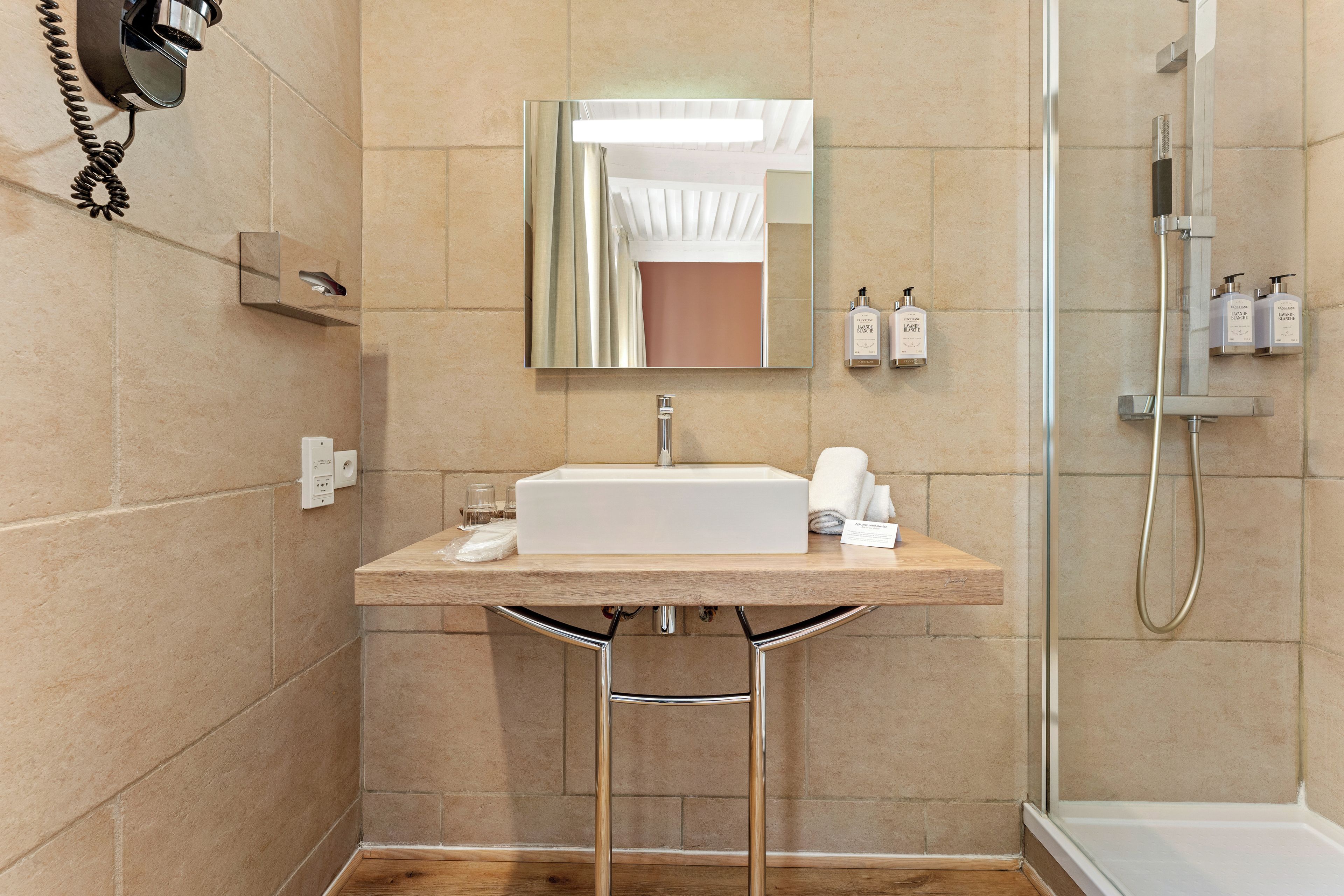 Une salle de bain moderne avec un lavabo, un miroir et une douche.
