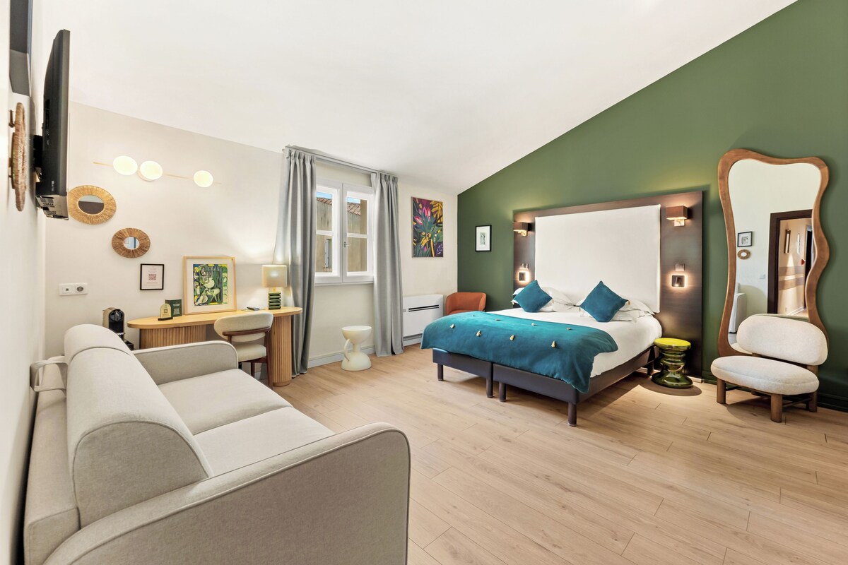Un dormitorio moderno con cama, escritorio, silla y sofá.