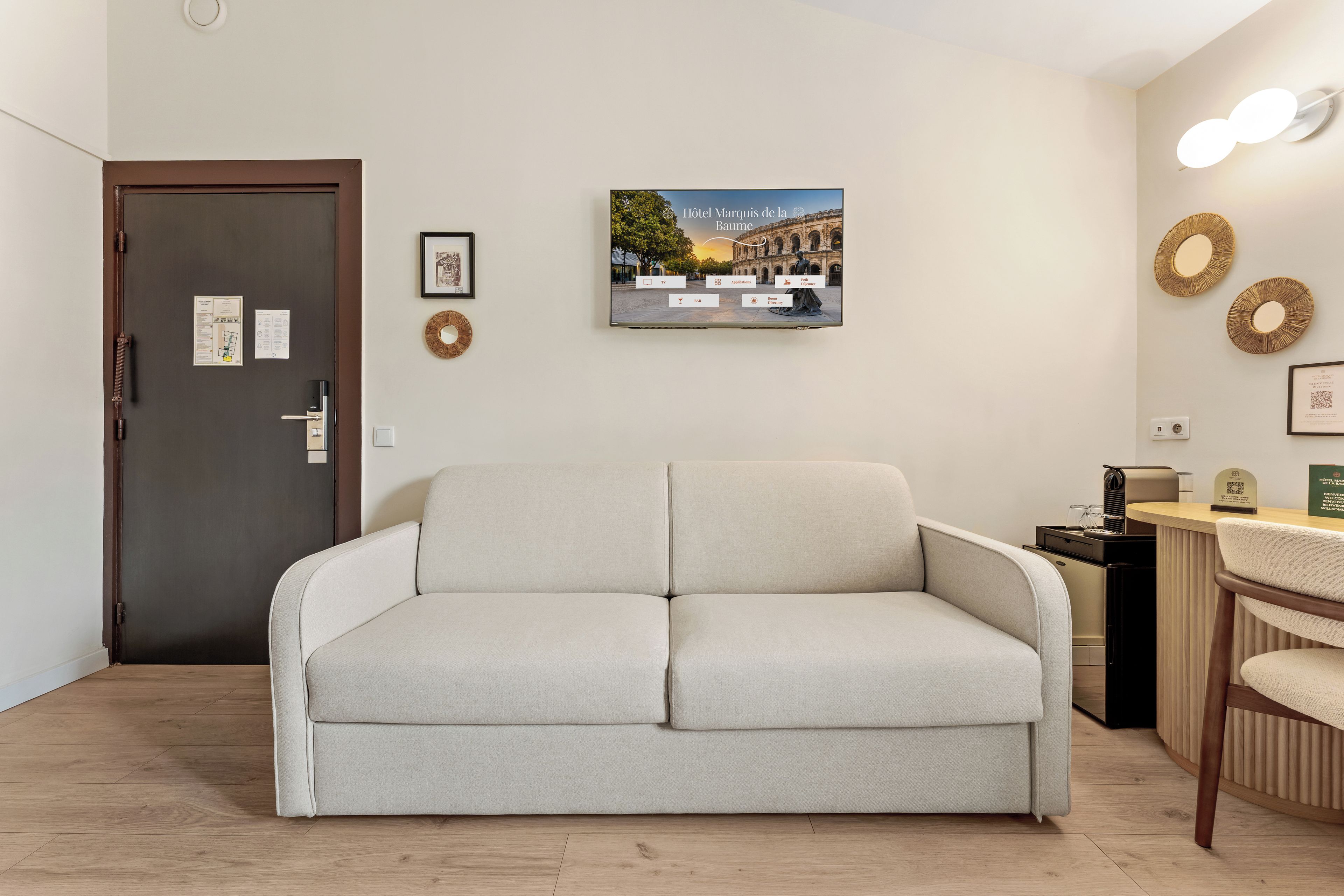 A hotel lobby with a sofa, a reception desk, and a framed picture of a historic building.