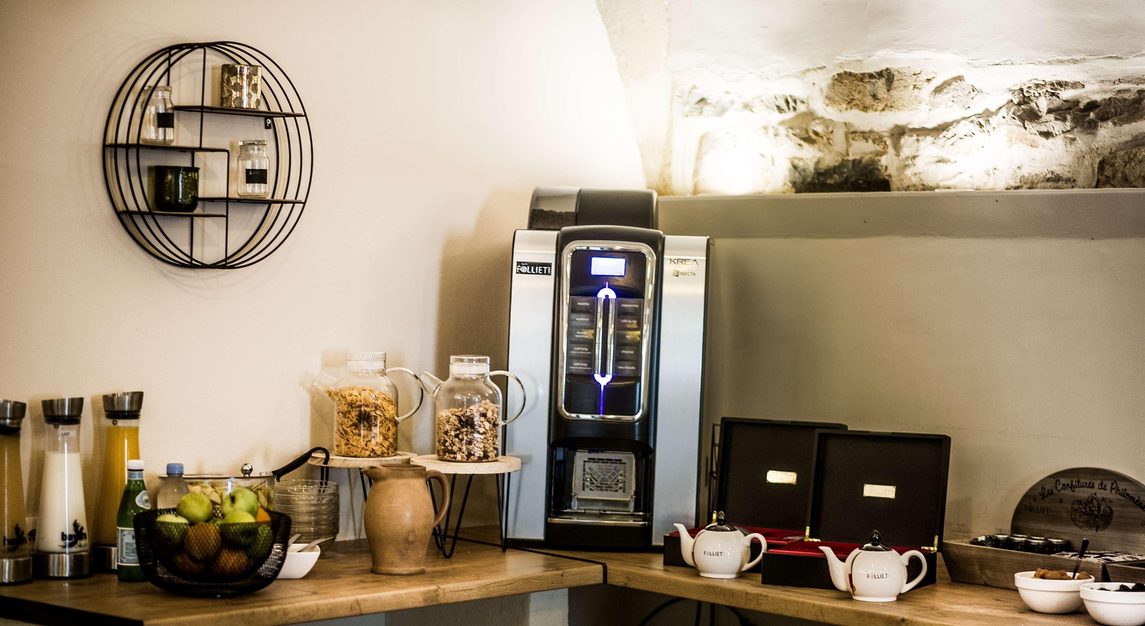 Een aanrecht met een koffiezetapparaat, een waterkoker en diverse keukengerei.