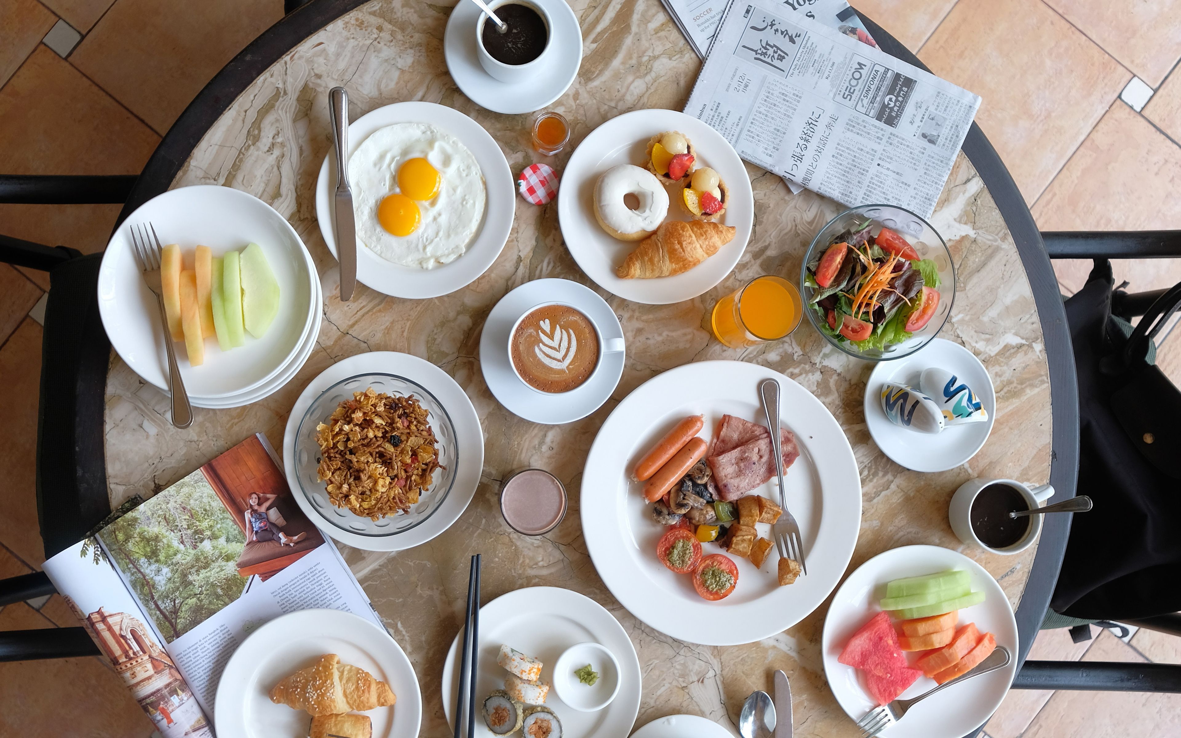 Una mesa de desayuno con diversos platos, incluyendo huevos, croissants y una ensalada.