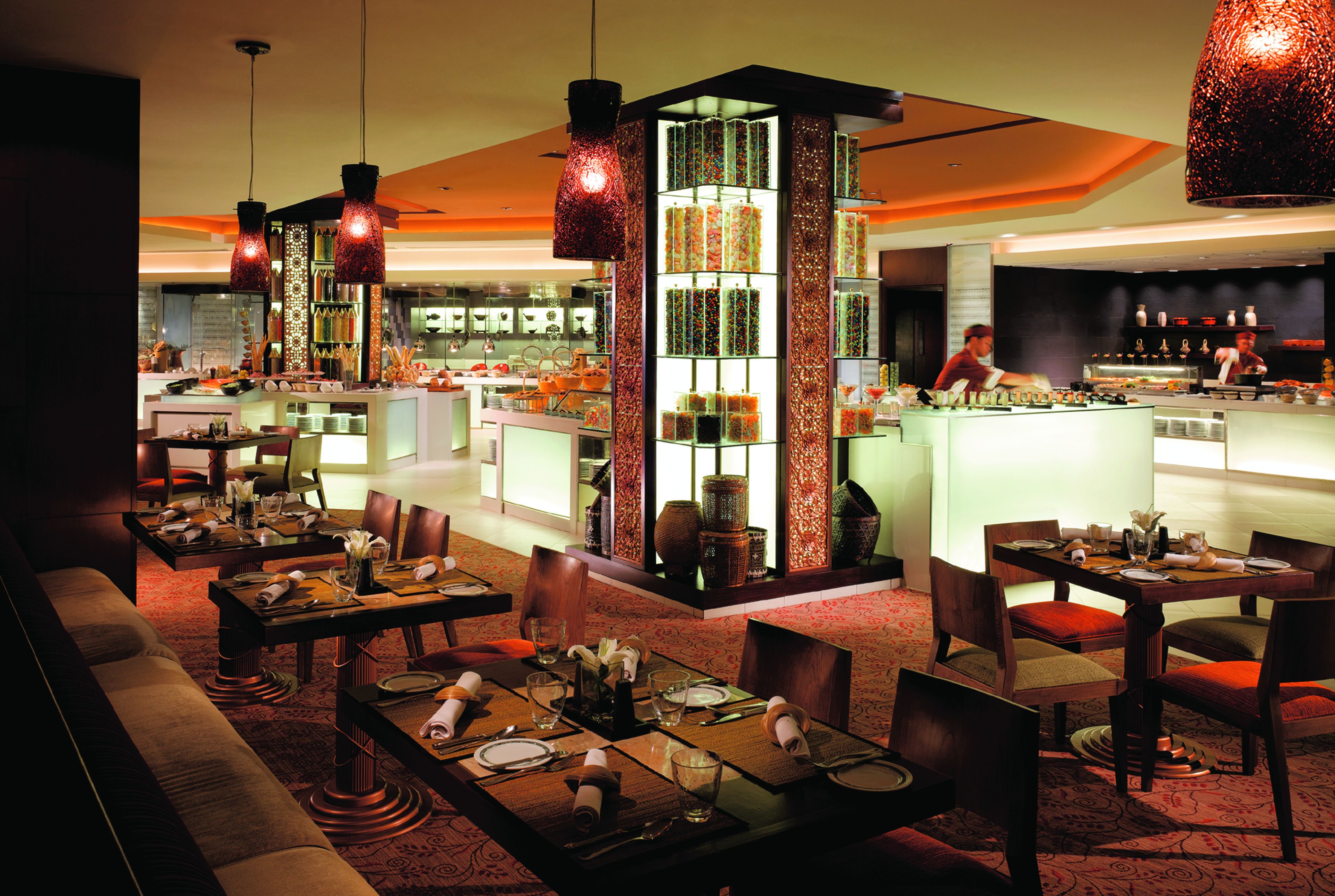 A restaurant with multiple dining tables, chairs, and a bar area.