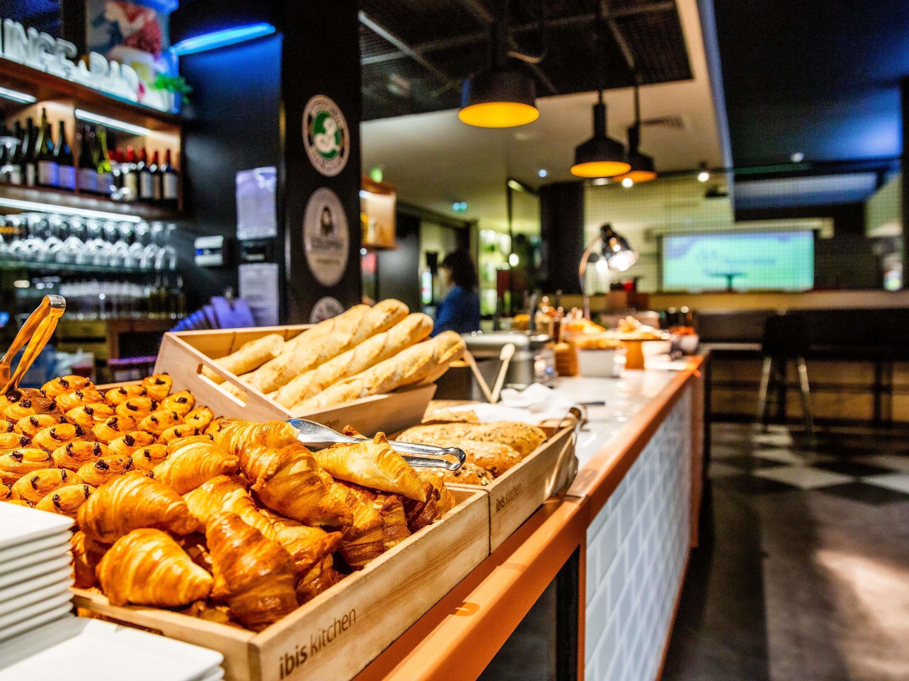 A buffet with various baked goods, including croissants and bread rolls.