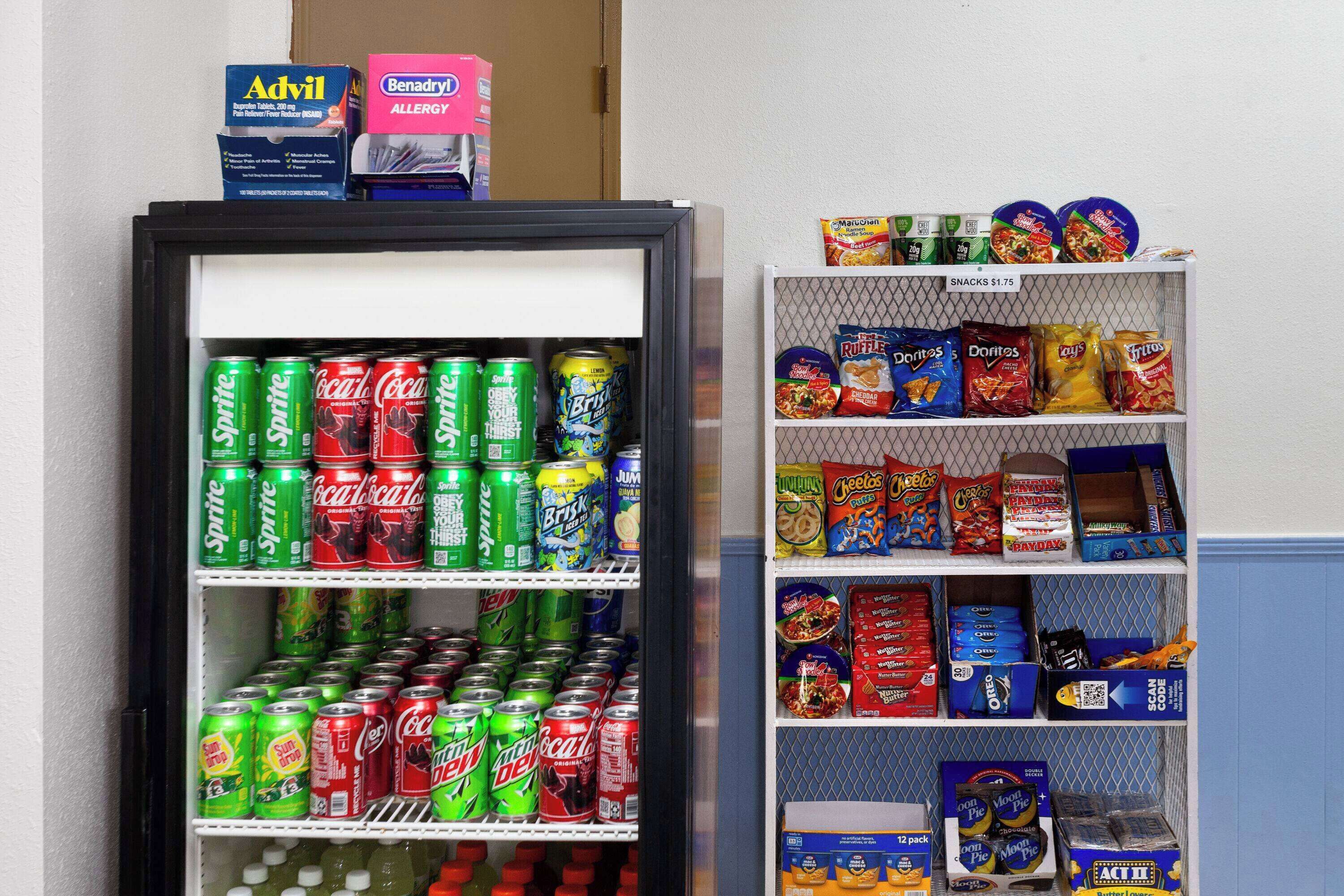 A vending machine stocked with various snacks and drinks, including soda cans and chips.
