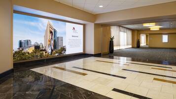 A spacious lobby with a large cityscape mural, a reception desk, and a modern tiled floor.