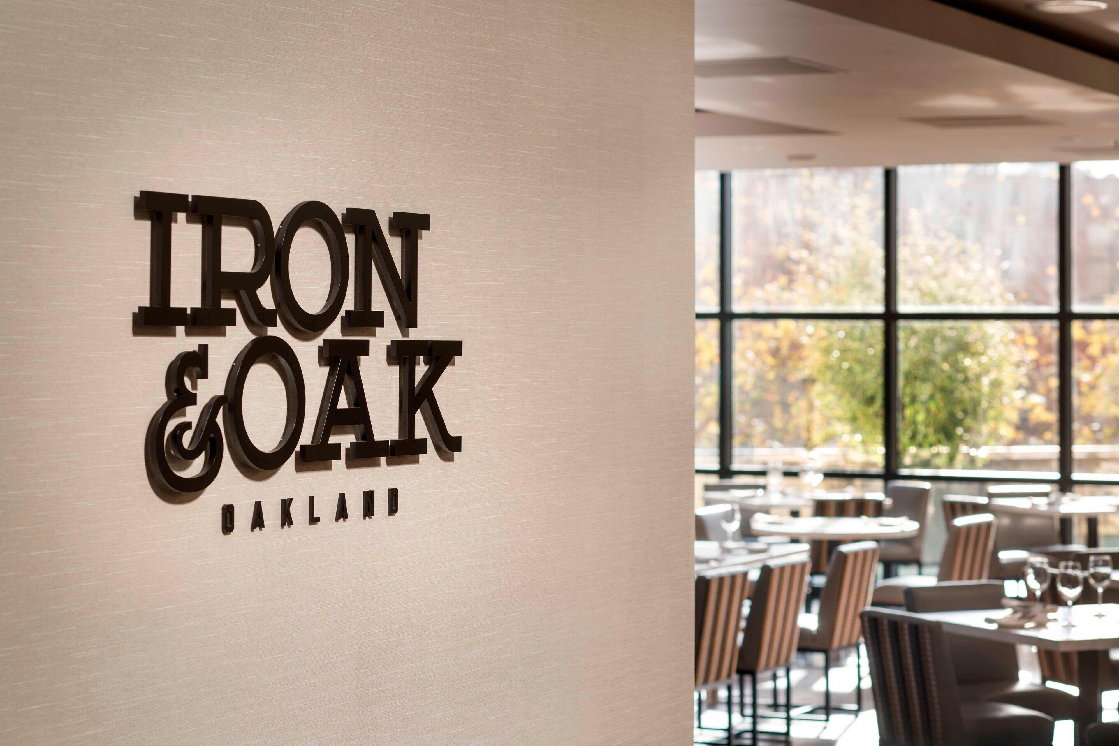 Ein Restaurantinnenraum mit einem Schild, auf dem 'IRON & OAK OAKLAND' steht.
