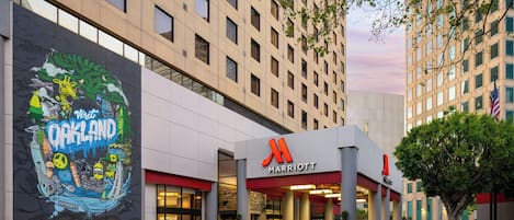 A Marriott hotel with a large mural advertising Oakland attractions.