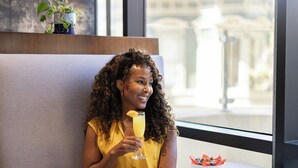 A person seated at a table with a bowl of fruit and a glass of orange juice. - Oakland Marriott City Center (Oakland)