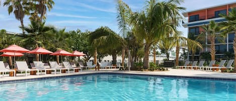 Alberca al aire libre, sombrillas en la alberca y camastros