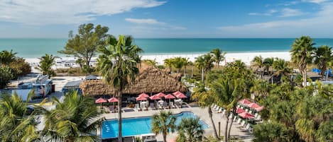 Ein Resort mit Pool, Strand und Palmen.