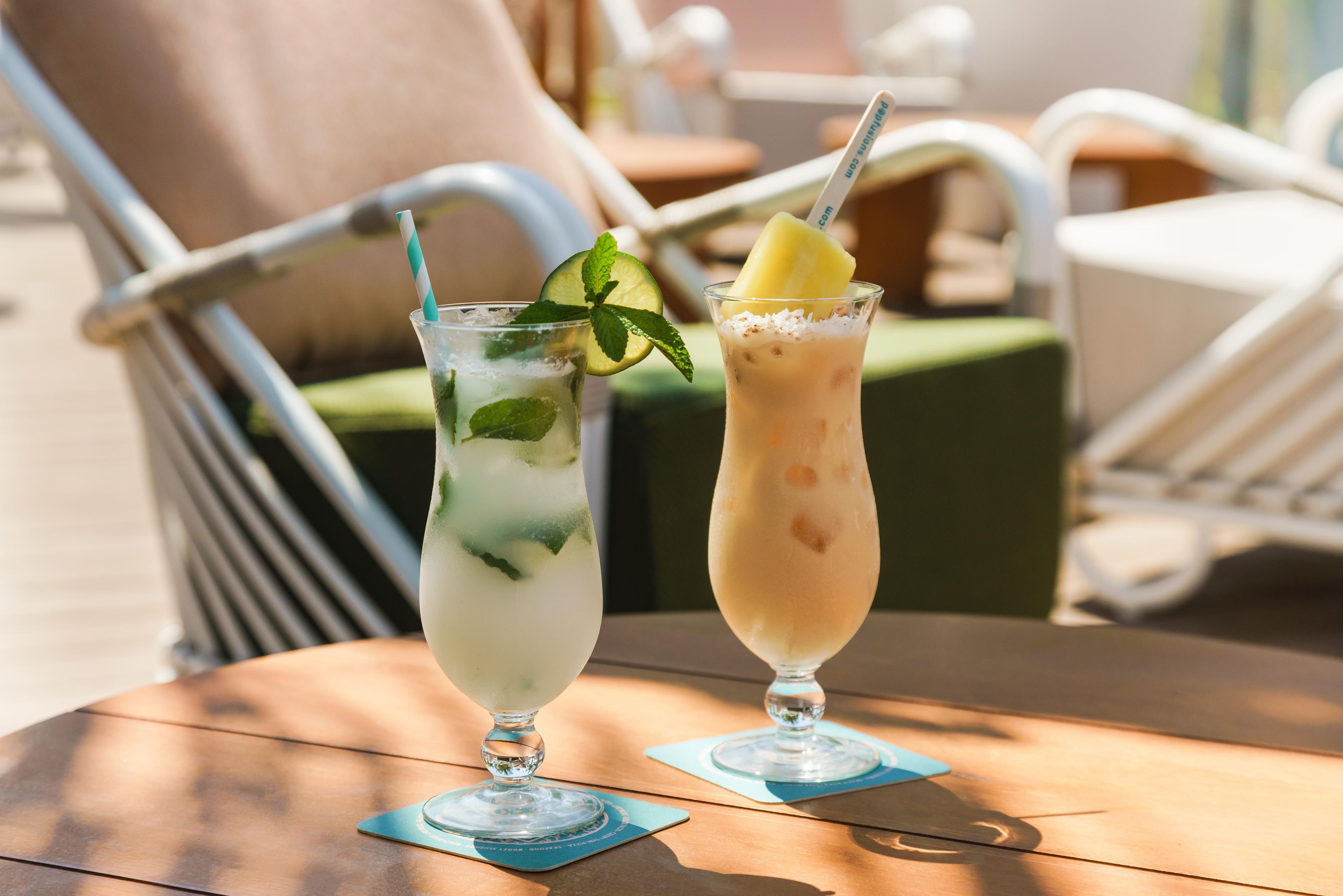 Dos bebidas sobre una mesa con una silla al fondo.