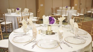 A banquet hall with round tables set for a formal event, featuring white tablecloths, gold beaded table settings, and floral centerpieces. - Holiday Inn Diamond Bar - Pomona by IHG (Diamond Bar)