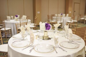 A banquet hall with round tables set for a formal event, featuring white tablecloths, gold beaded table settings, and floral centerpieces. - Holiday Inn Diamond Bar - Pomona by IHG (Diamond Bar)