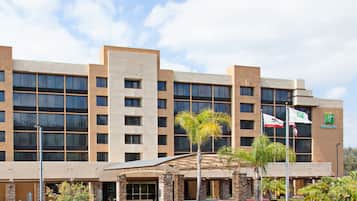 Welcome to Holiday Inn Express, featuring modern architecture with rectangular windows and a flat roofline, surrounded by lush landscaping.