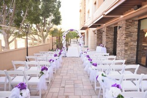 An outdoor wedding aisle with white chairs and floral decorations. - Holiday Inn Diamond Bar - Pomona by IHG (Diamond Bar)