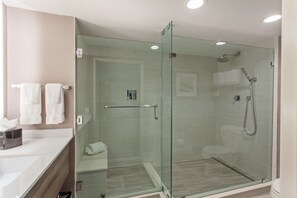 A modern bathroom with a glass-enclosed shower, a white sink, and a toilet. - Holiday Inn Diamond Bar - Pomona by IHG (Diamond Bar)