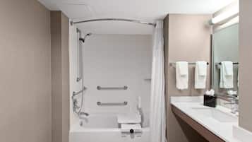 A modern bathroom with a bathtub, shower, and vanity.
