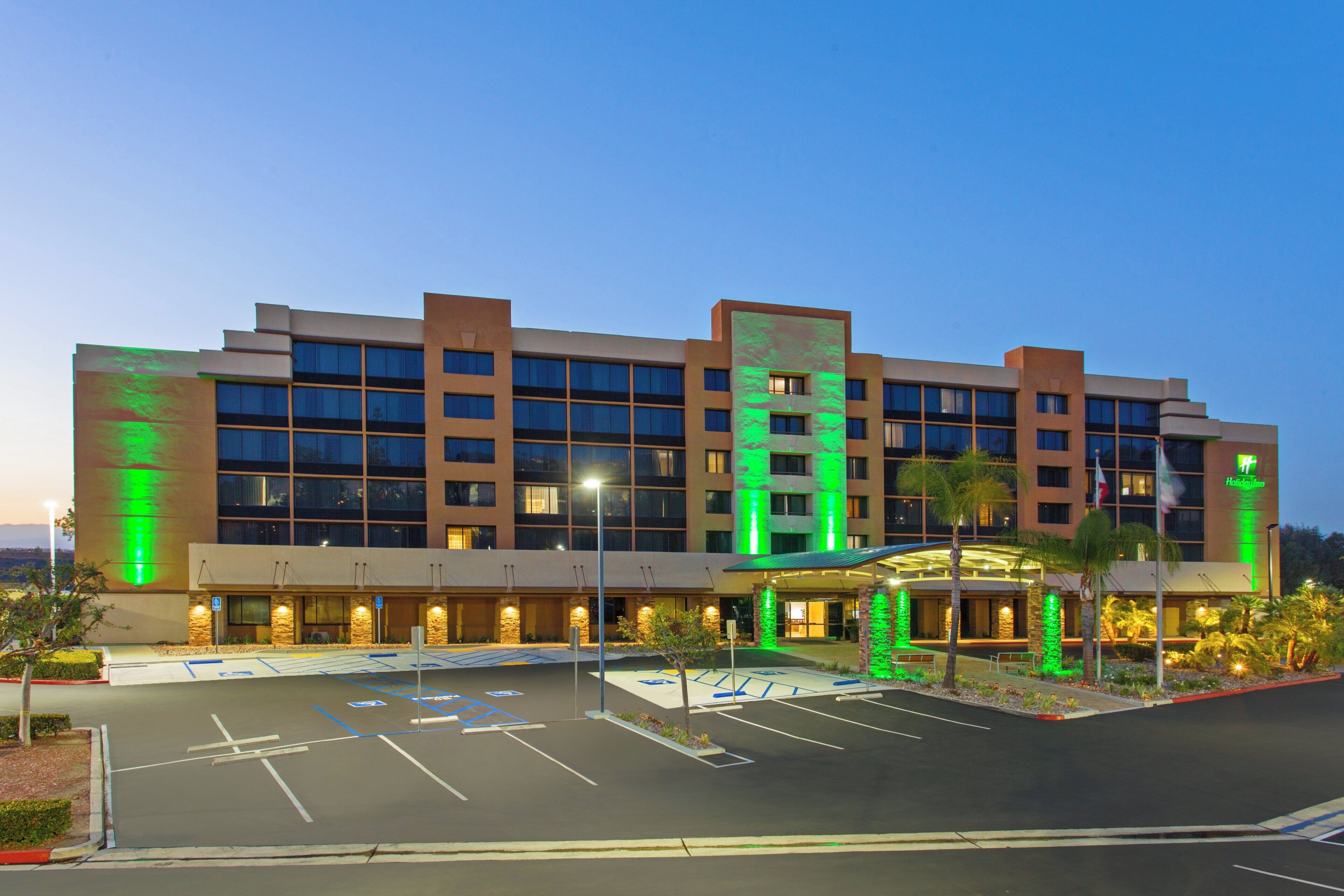 A multi-story hotel with a parking lot in front.