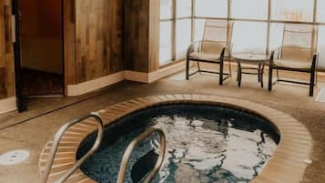 Area piscina con cartello che indica le regole, vasca idromassaggio e posti a sedere.
